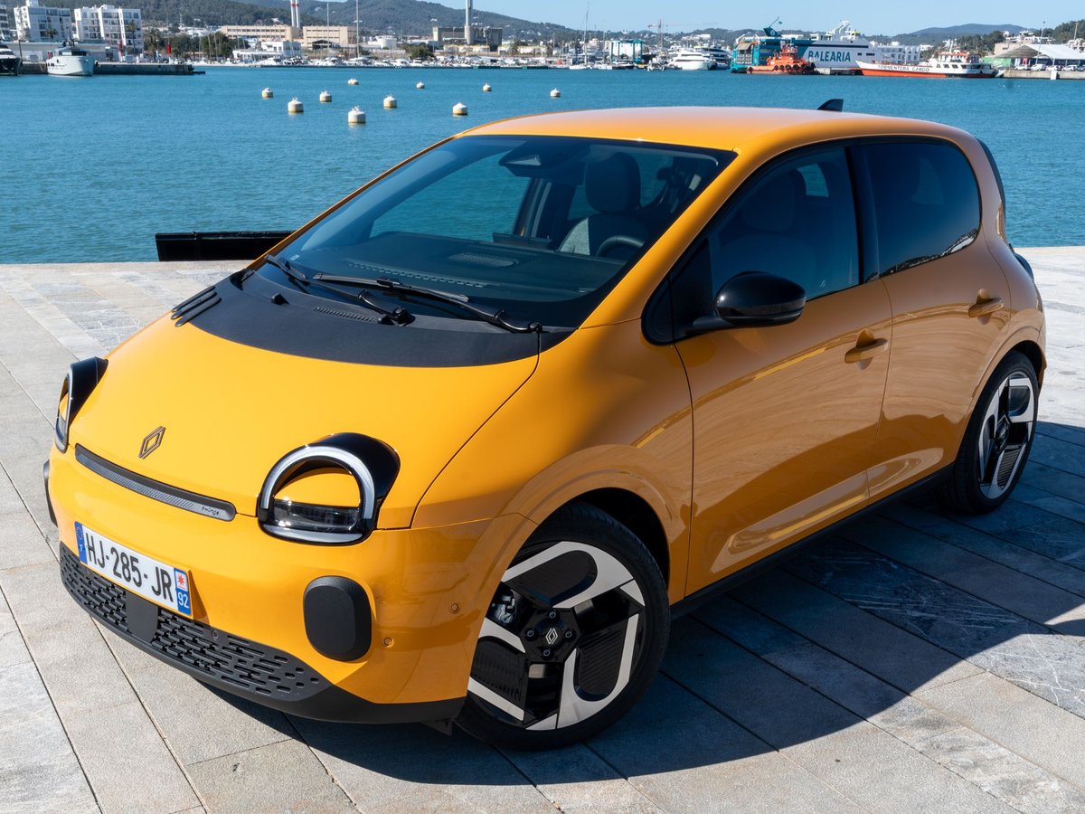 Renault Twingo E-Tech électrique jaune Mango en finition Techno avec jantes 18 pouces, vue 3/4 avant au bord de l’eau