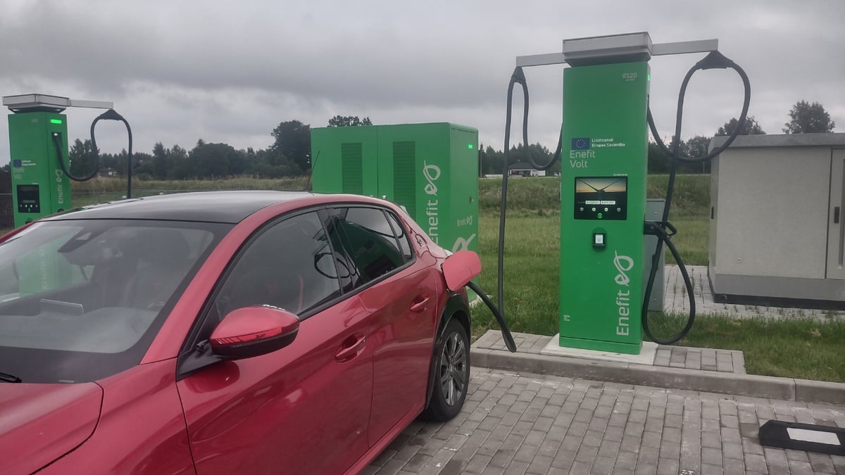 Peugeot e-208 rouge branchee sur une borne de recharge rapide verte Enefit Volt en Estonie