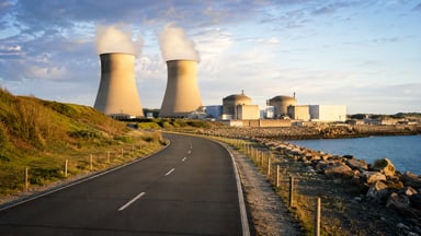 Centrale nucléaire française en bord de mer avec ses tours de refroidissement et ses dômes de réacteurs au coucher du soleil