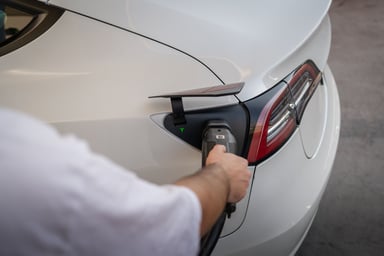 Conducteur branchant le câble de recharge sur une voiture électrique à domicile