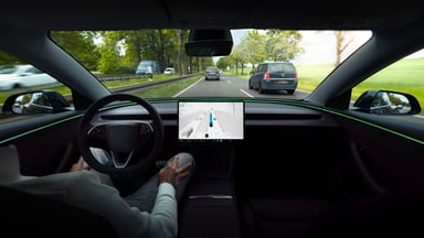 Vue intérieure d'une Tesla Model 3 montrant l'écran de navigation FSD en circulation.