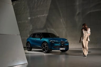 Alfa Romeo Junior électrique bleue de trois quarts avant dans un showroom