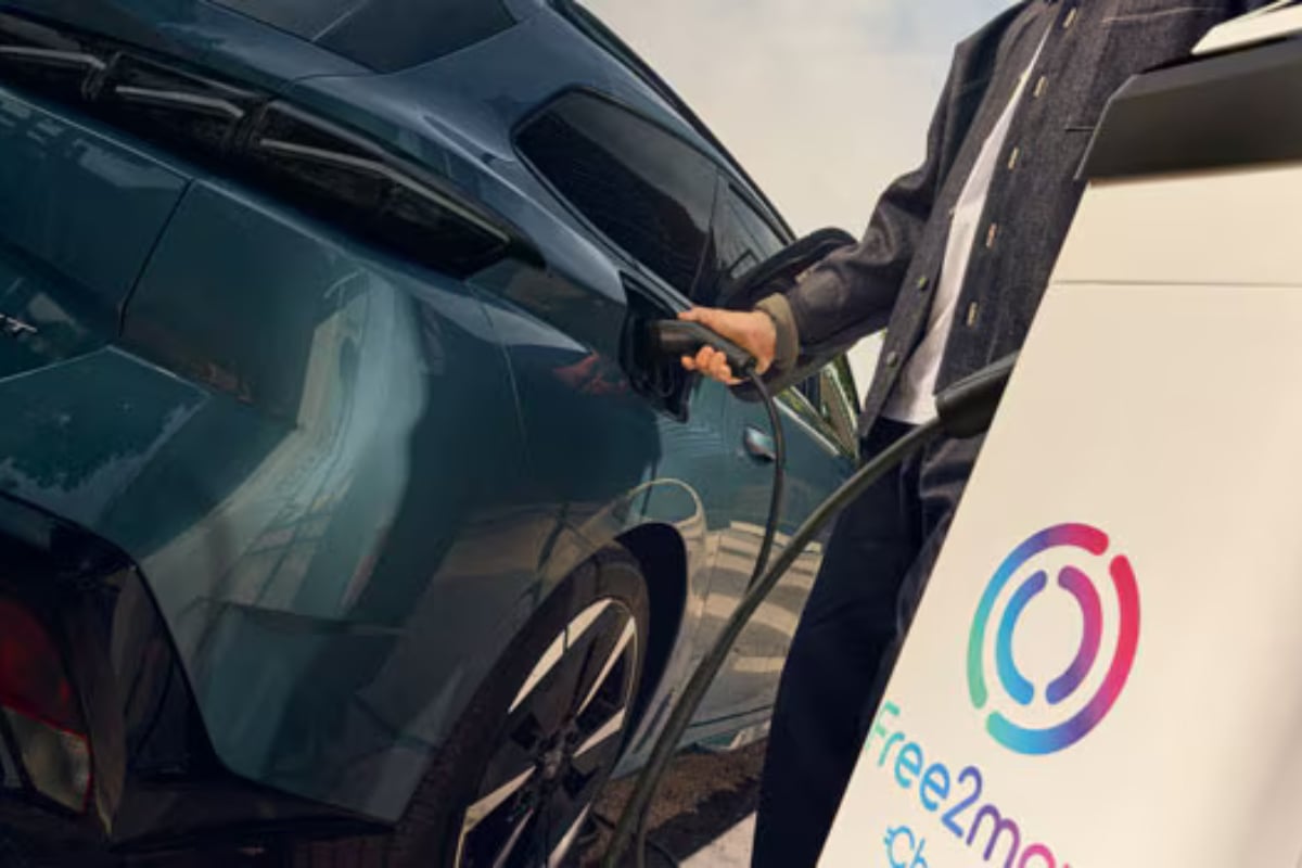 Peugeot E-308 SW électrique bleue en cours de recharge sur une borne publique du réseau Free2move, un critère clé de notre guide d'achat.