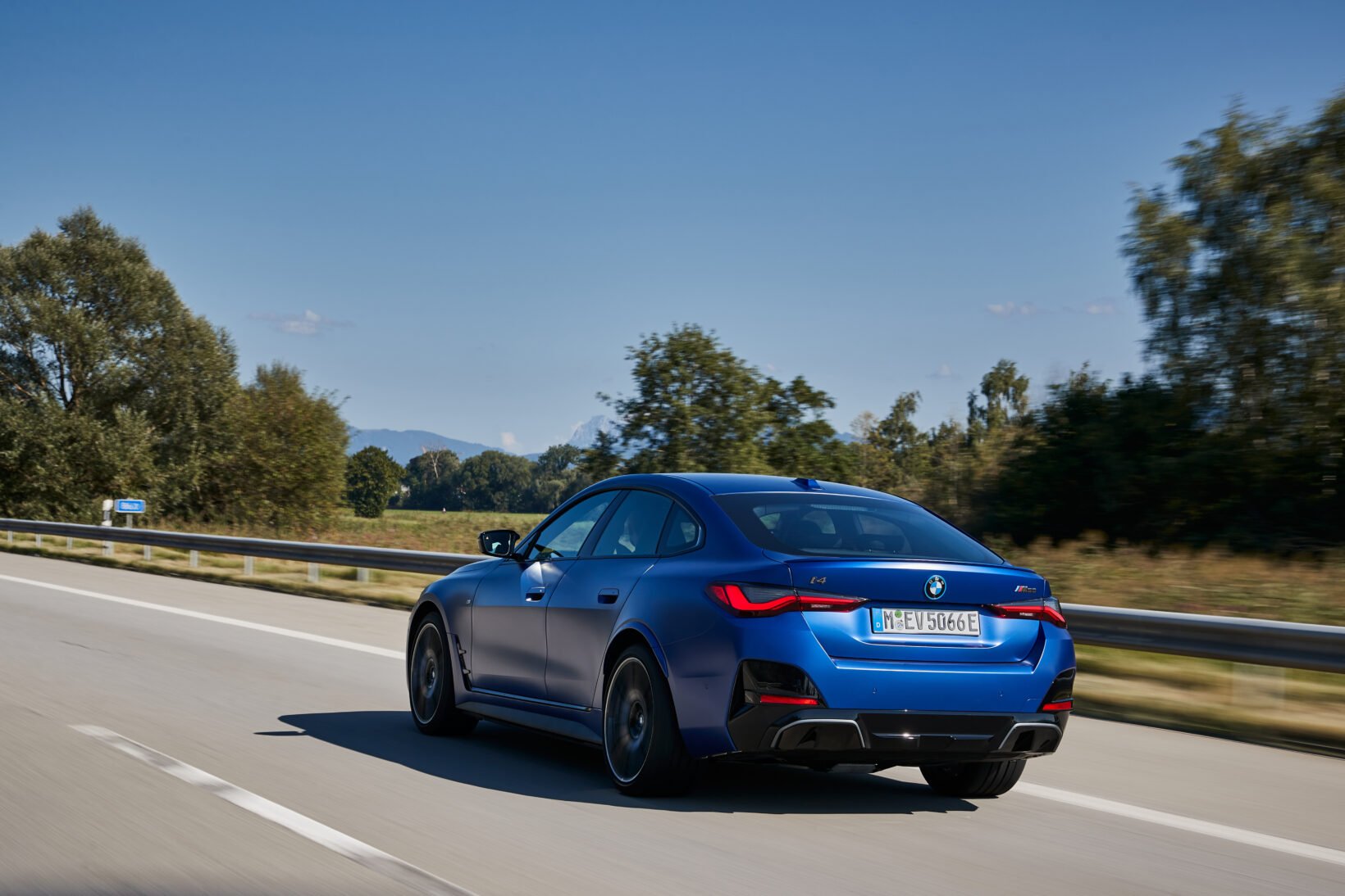 BMW i4 électrique roulant sur une route, en voiture de fonction d'entreprise