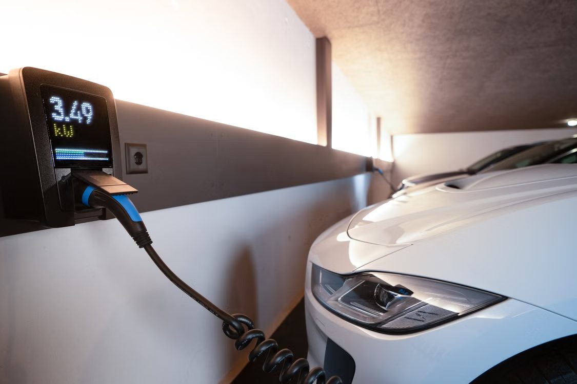 Écran d'une borne de recharge affichant 3,49 kW, câble Type 2 branché sur une voiture électrique blanche
