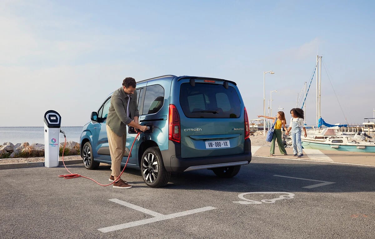 Conducteur branchant un Citroën ë-Berlingo électrique sur une borne de recharge publique