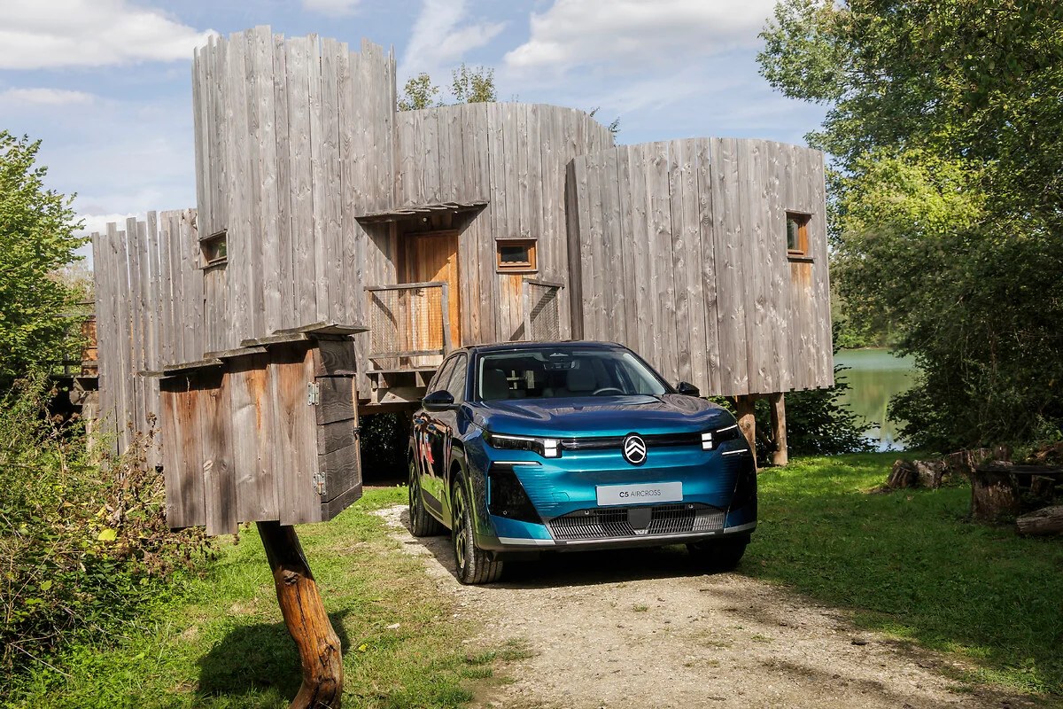 Citroën ë-C5 Aircross 2026 bleu devant une cabane en bois au bord d'un lac