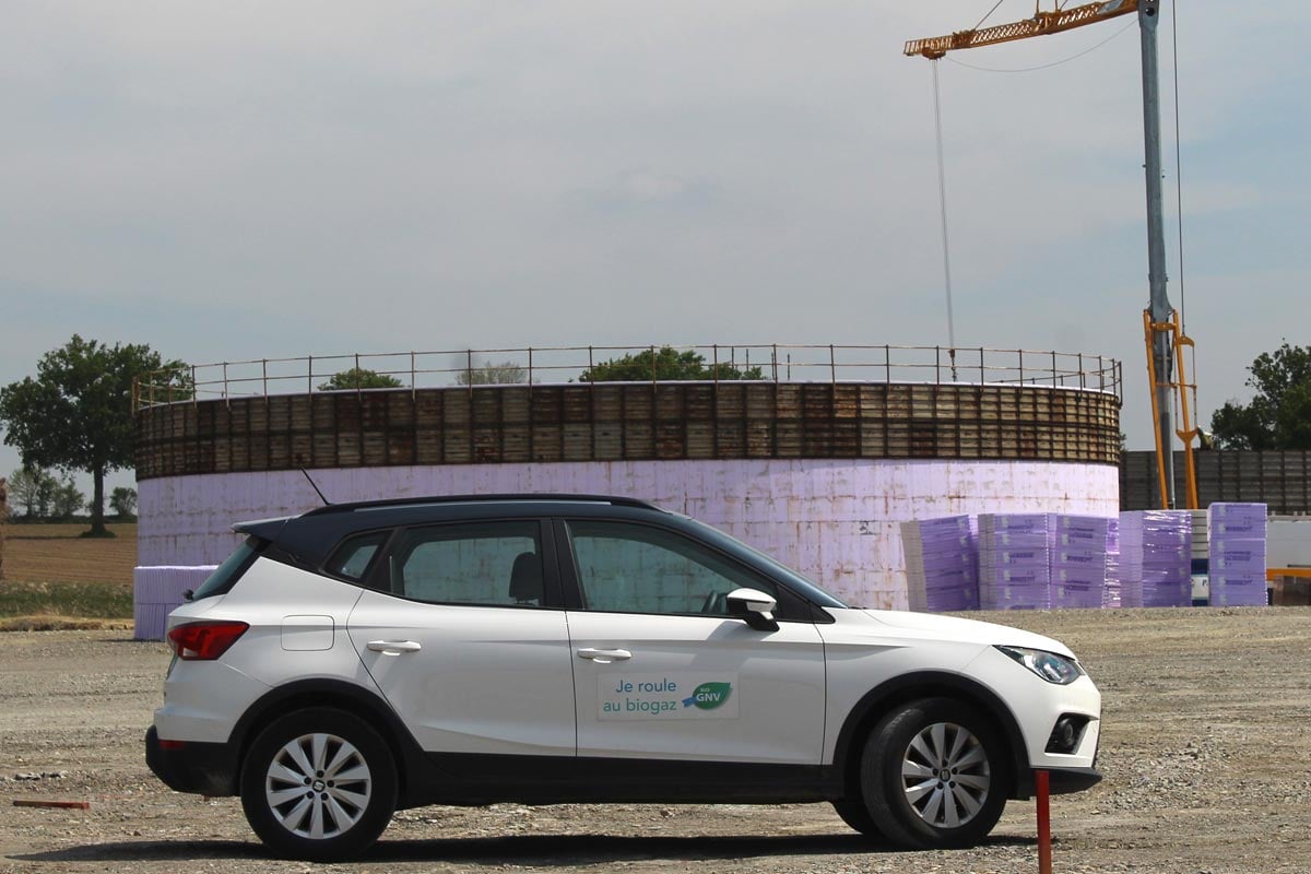 Voiture GNV devant une unité de méthanisation en construction