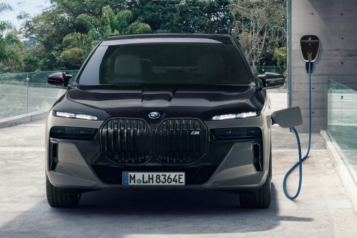 Voiture hybride rechargeable branchée à une borne de recharge murale, illustrant la nécessité de brancher son PHEV pour profiter du mode 100% électrique.