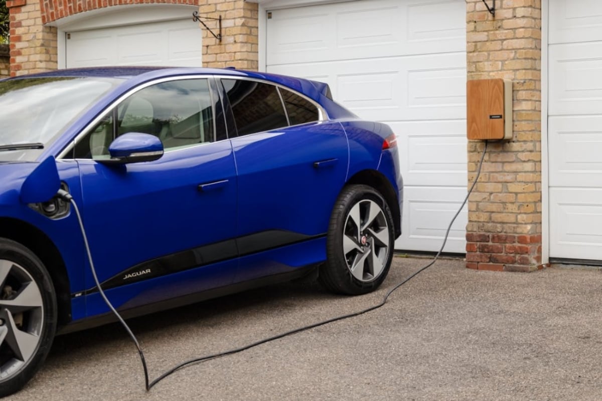 Comparaison des modes de recharge montrant une voiture électrique branchée sur une borne wallbox dans un garage et sur une place de stationnement extérieure.