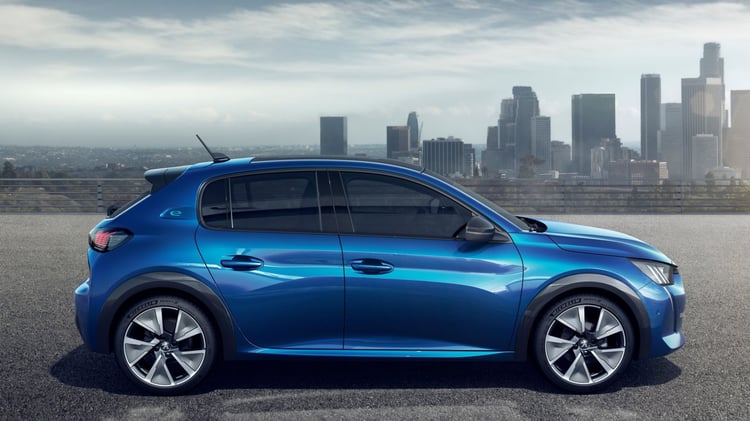 Peugeot 208 électrique première génération vue de profil avec skyline urbaine