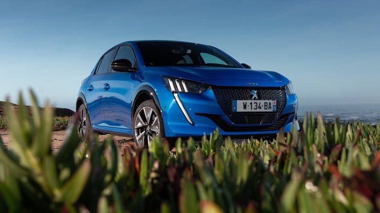 Peugeot 208 électrique première génération vue trois quarts avant stationnée près de l’océan