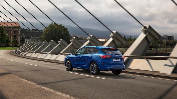 Ford Kuga hybride rechargeable bleu roulant sur un pont, SUV hybride rechargeable de 243 ch