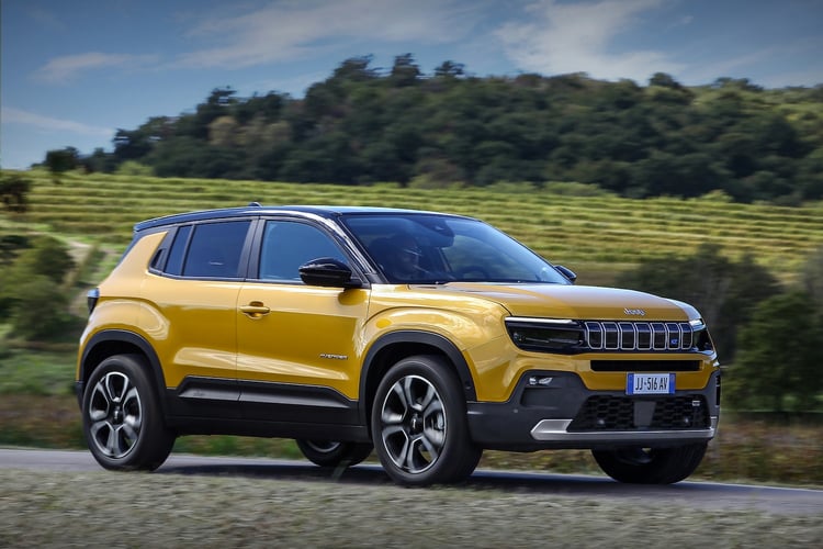 Jeep Avenger électrique jaune roulant sur une route de campagne vue trois-quarts avant