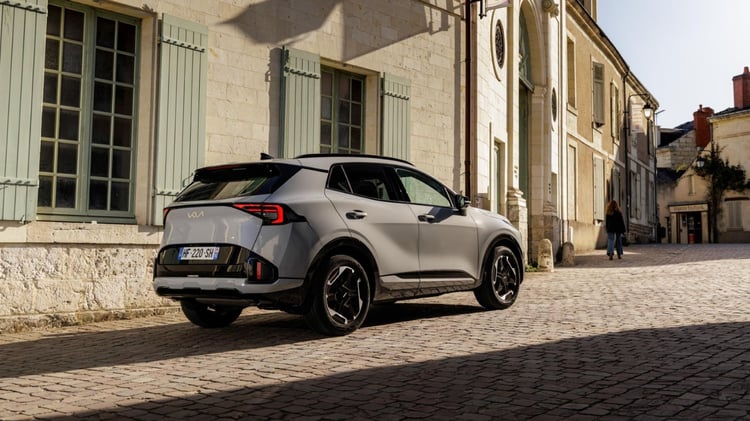 Kia Sportage hybride vu de l’arrière en milieu urbain, SUV compact de 4,54 m de long