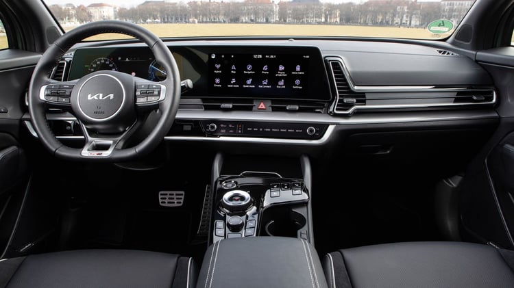 Habitacle du Kia Sportage hybride de première génération avec double écran numérique et console centrale à sélecteur rotatif