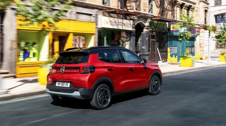 Citroën ë-C3 électrique en circulation en ville, vue arrière trois-quarts