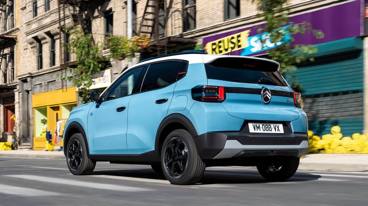 Citroën ë-C3 électrique en circulation en ville, vue arrière trois-quarts