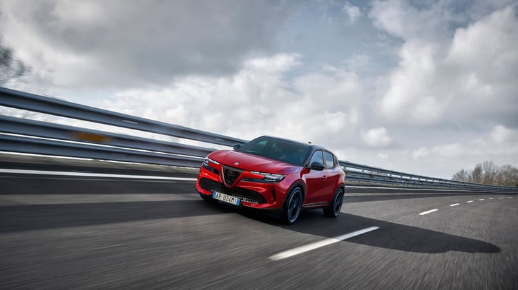 Alfa Romeo Junior électrique Veloce rouge en mouvement sur route avec motorisation de 280 ch