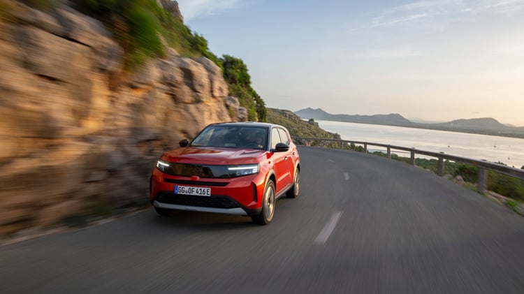Opel Frontera électrique rouge en conduite sur route côtière sinueuse