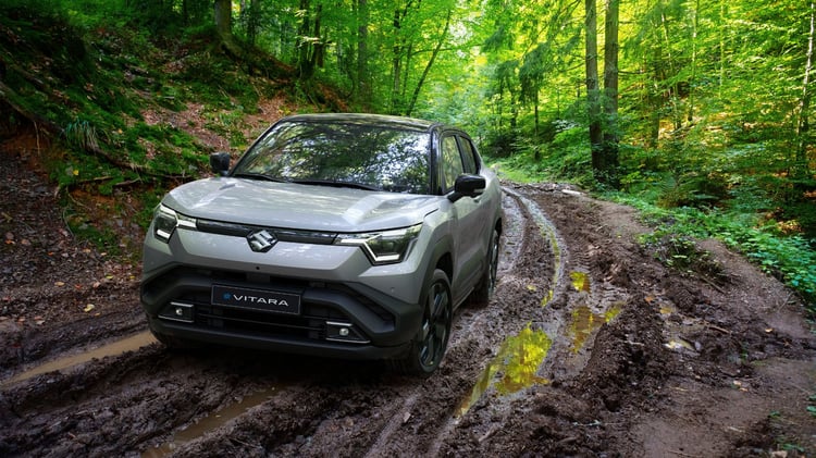Suzuki e Vitara électrique circulant sur un chemin forestier boueux