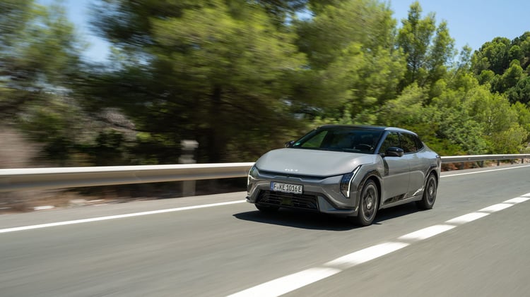 Kia EV4 Fastback électrique roulant sur route, vue avant trois-quarts.