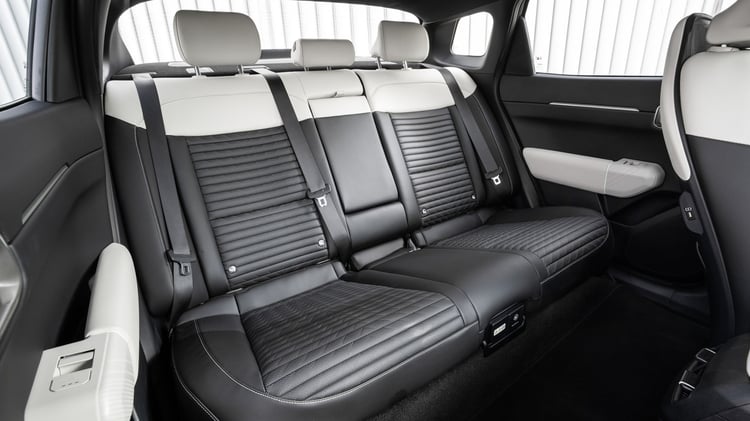 Banquette arrière de la Kia EV4 Fastback avec trois appuie-têtes et sellerie bicolore.