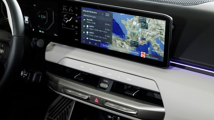 Écran panoramique de la Kia EV4 affichant la navigation avec planificateur d’itinéraire et informations de recharge.