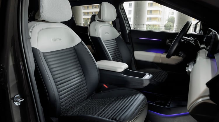 Habitacle avant de la Kia EV4 avec sièges avant en sellerie bicolore et console centrale flottante.