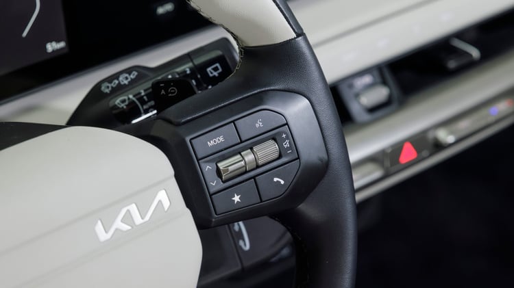 Volant multifonctions de la Kia EV4 avec commandes intégrées pour l’infodivertissement, les appels et les modes de conduite.