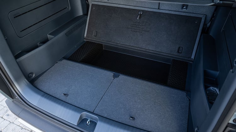 Rangement sous plancher du coffre du Kia PV5 Passenger avec trappe ouverte