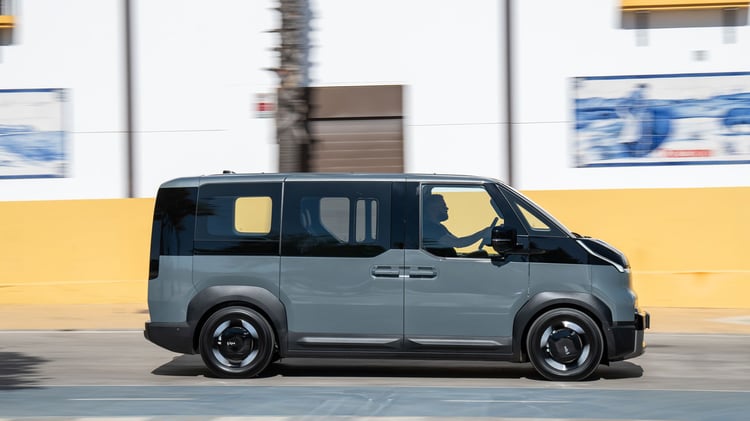 Kia PV5 Passenger électrique en roulage vu de profil, van cinq places avec portes coulissantes