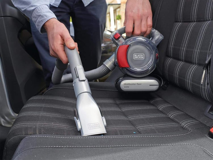 Aspirateur à main Black+Decker Dustbuster Flexi nettoyant le siège textile d'une voiture
