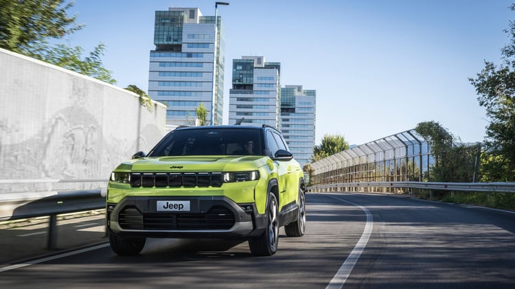 Jeep Compass électrique vert en conduite sur route, SUV compact 213 ch et batterie 74 kWh