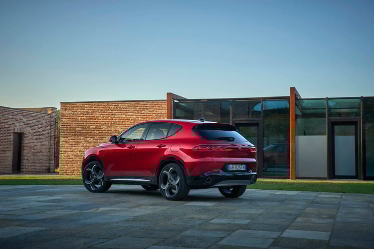 Alfa Romeo Tonale Plug-In Q4 rouge stationnée sur route, SUV hybride rechargeable italien design moderne
