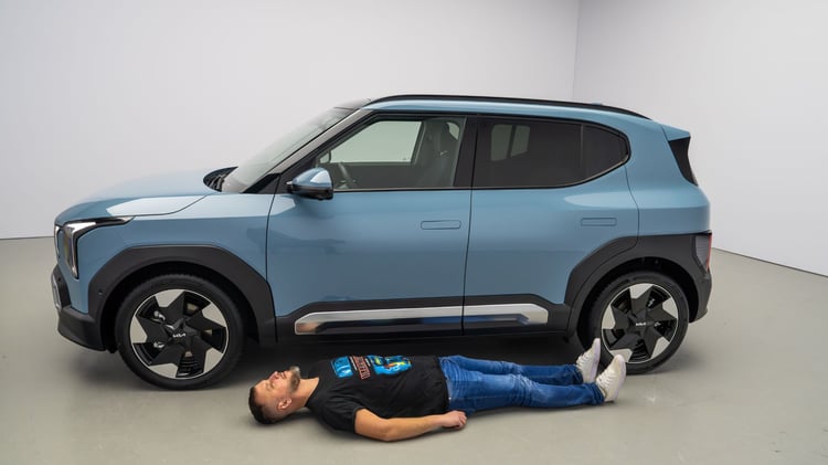 Kia EV2 de profil avec une personne allongée au sol pour montrer l'empattement.