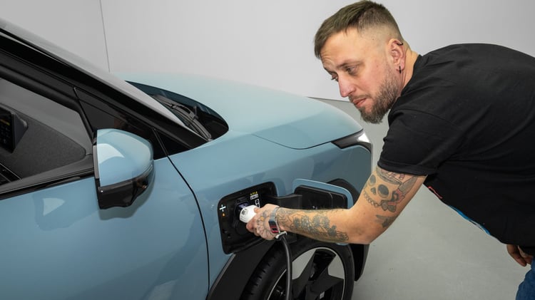 Recharge de la Kia EV2 : branchement du câble sur la prise située à l’avant, côté gauche du SUV électrique compact.