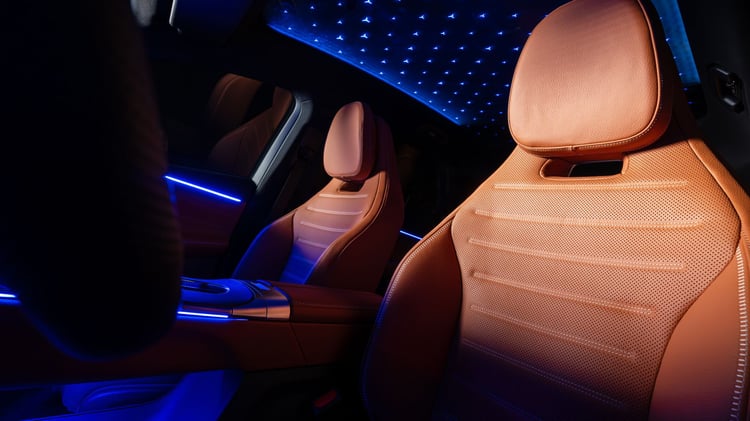 Habitacle du Mercedes GLC électrique avec sièges avant en cuir, éclairage d’ambiance et toit panoramique illuminé
