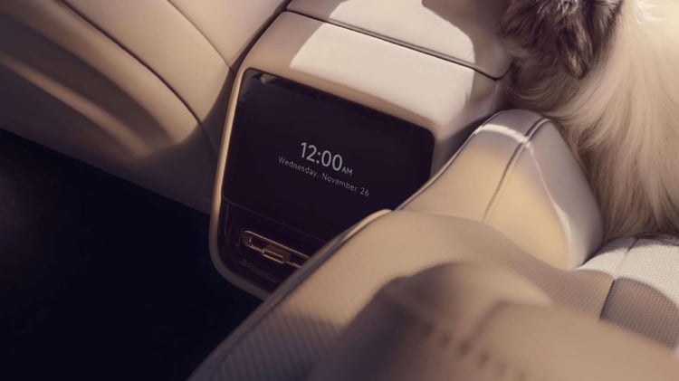 Écran arrière dans l’habitacle de la XPeng P7+ avec sellerie claire et commandes de ventilation