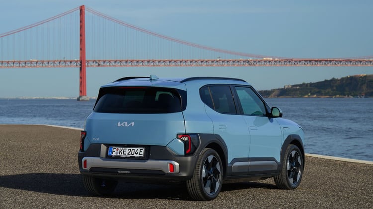 Kia EV2 électrique bleu givré finition Earth vue trois quarts arrière bord de mer