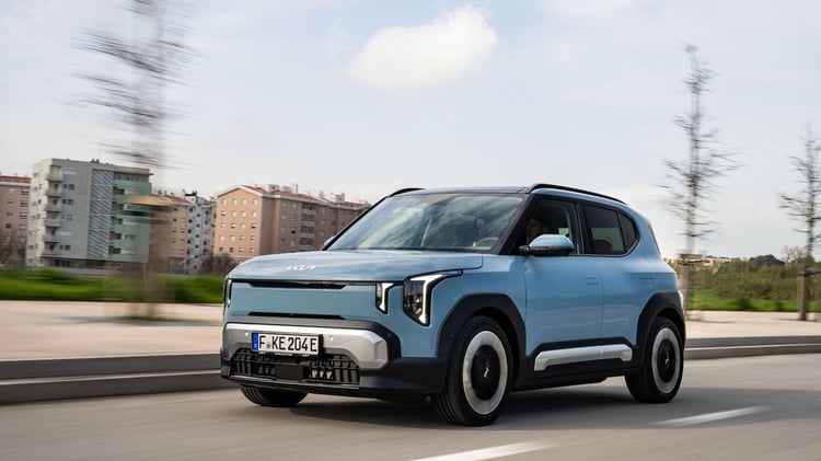 Kia EV2 électrique bleu givré en mouvement vue trois quarts avant sur route