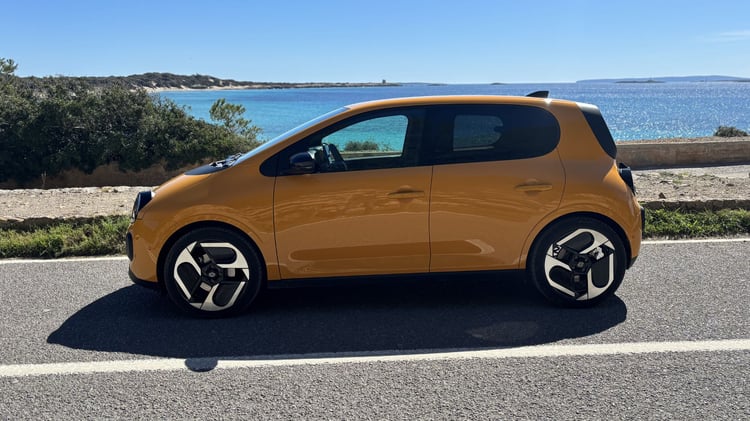 Profil Renault Twingo E-Tech électrique jaune Mango avec jantes 18 pouces sur route en bord de mer