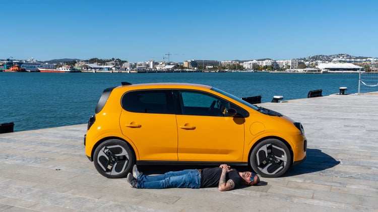 Renault Twingo E-Tech électrique jaune Mango profil avec jantes 18 pouces, homme allongé pour illustrer l’empattement