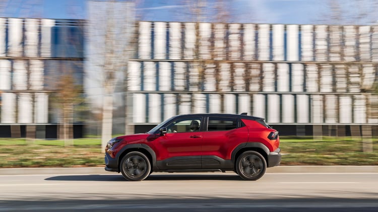 Suzuki e Vitara électrique rouge en mouvement vue de profil sur route