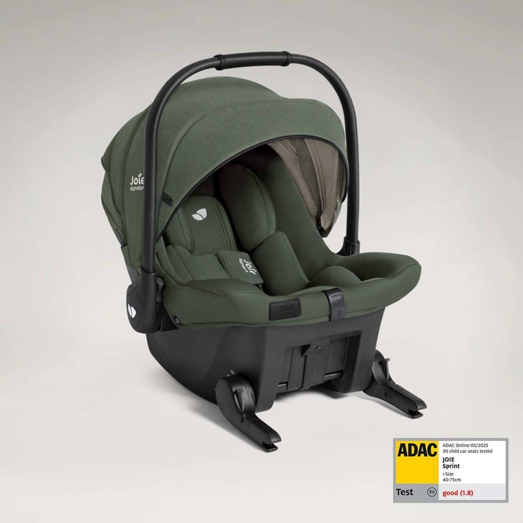 Coque bébé Joie Sprint i-Size verte posée sur sa base ISOFIX à jambe de force