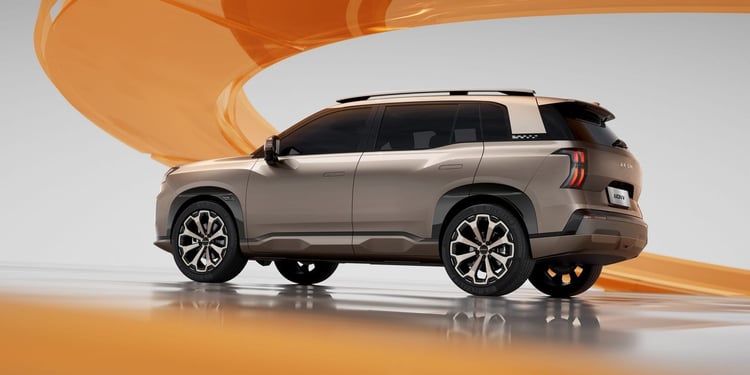 Aion V vue 3/4 arrière en studio, SUV électrique beige avec jantes bicolores et barres de toit