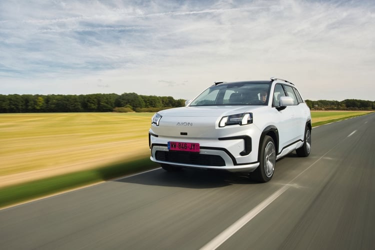 SUV électrique Aion blanc vu de trois-quarts avant en roulage sur une route de campagne