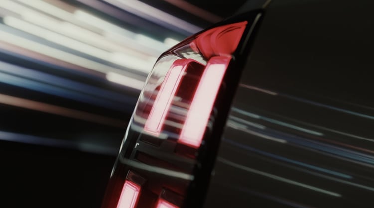 Gros plan sur le feu arrière vertical à LED d'une voiture sombre, avec filé lumineux en arrière-plan