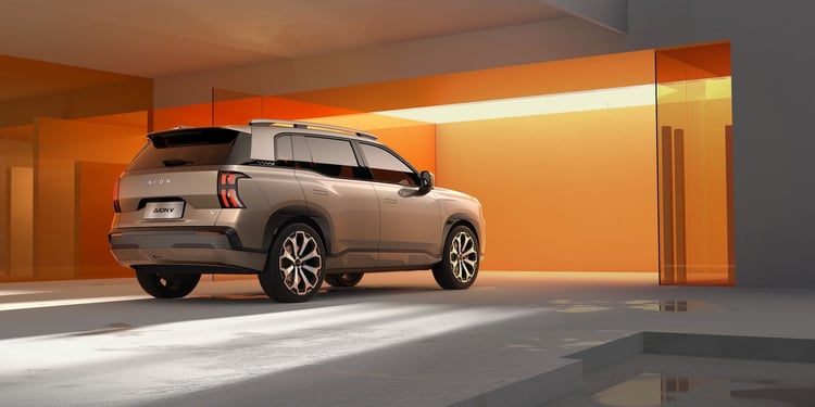 Aion V vue 3/4 arrière, SUV électrique beige avec feux verticaux et barres de toit