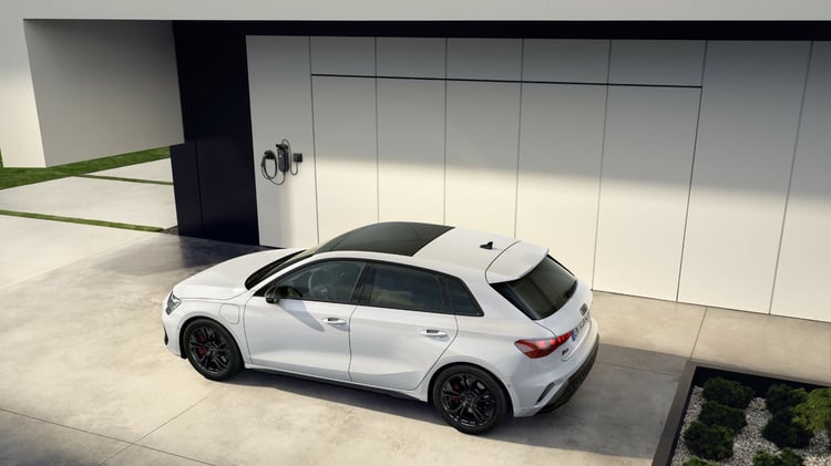 Audi A3 Sportback hybride rechargeable stationnée devant une borne de recharge murale